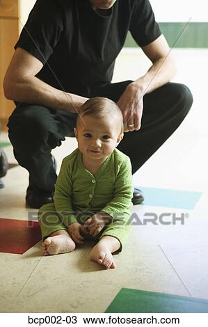 A baby sitting on kitchen floor with his dad. View Large Photo Image Stock Image - A baby sitting on kitchen floor with his dad.. Fotosearch