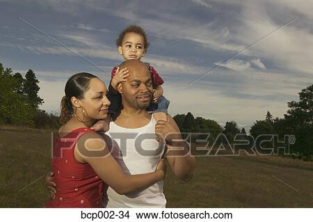 A family hugging in a green meadow. View Large Photo Image Picture - A family hugging in a green meadow. . Fotosearch