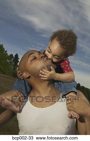 Stock Image - A father kissing his son. . Fotosearch