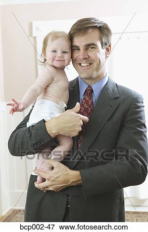 A father wearing a business suit and holding his baby. View Large Photo Image Stock Photo - A father wearing a business suit and holding his baby. . Fotosearch