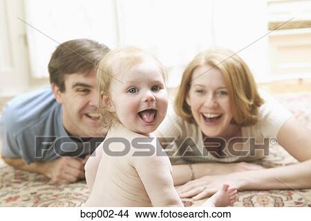 A mother and father smiling at their baby. View Large Photo Image Picture - A mother and father smiling at their baby. . Fotosearch
