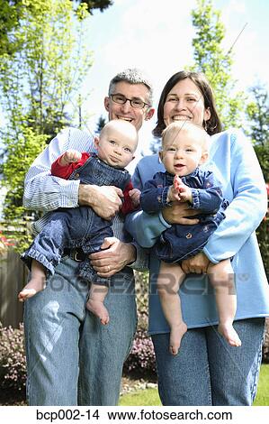 A mother and father with twin babies. View Large Photo Image Picture - A mother and father with twin babies.. Fotosearch