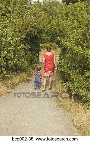 A mother walking with her toddler son. View Large Photo Image Stock Photo - A mother walking with her toddler son.. Fotosearch
