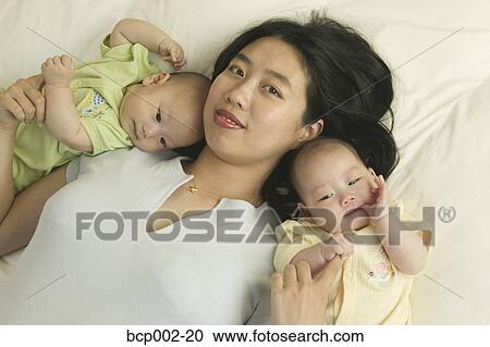 High angle portrait of a mom with her twin babies. View Large Photo Image Stock Image - High angle portrait of a mom with her twin babies. . Fotosearch