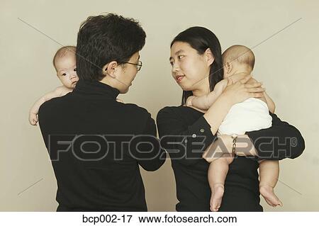 Parents holding their twin babies. View Large Photo Image Stock Photo - Parents holding their twin babies.. Fotosearch