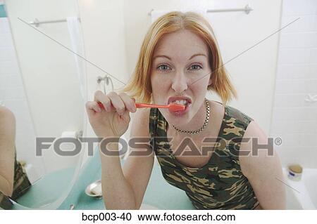 A red-headed woman brushing her teeth. View Large Photo Image Stock Image - A red-headed woman brushing her teeth.. Fotosearch