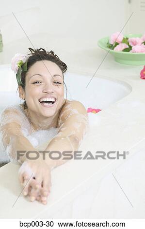 A woman smiling as she relaxes in a bathtub full of bubbles. View Large Photo Image Stock Image - A woman smiling as she relaxes in a bathtub full of bubbles.. Fotosearch