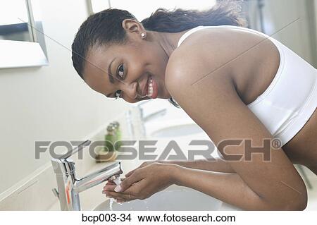 A young woman about to wash her face. View Large Photo Image Picture - A young woman about to wash her face.. Fotosearch