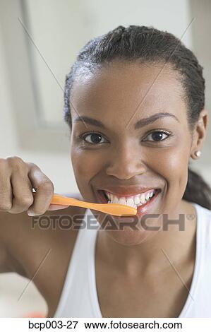 A young woman brushing her teeth. View Large Photo Image Stock Photo - A young woman brushing her teeth.. Fotosearch