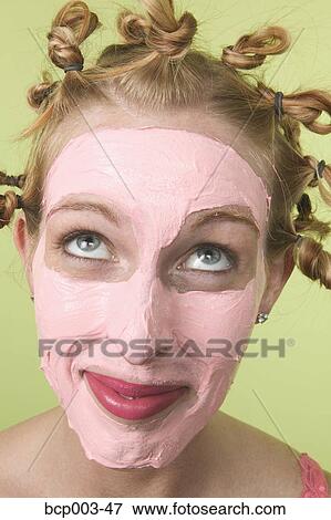 A young woman with facial mask and tight curls in her hair. View Large Photo Image Stock Photo - A young woman with facial mask and tight curls in her hair.. Fotosearch
