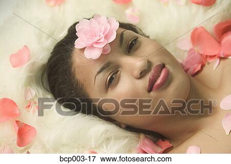 A young woman with flower petals on her forehead. View Large Photo Image Stock Photo - A young woman with flower petals on her forehead.. Fotosearch