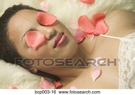 A young woman with flower petals covering her eyes. View Large Photo Image Stock Photograph - A young woman with flower petals covering her eyes.. Fotosearch