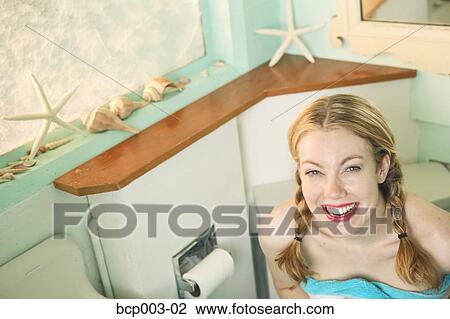 Stock Image - Blonde woman in her bathroom.. Fotosearch