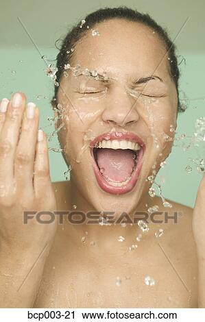 Stock Image - Close-up of a woman washing her face.. Fotosearch