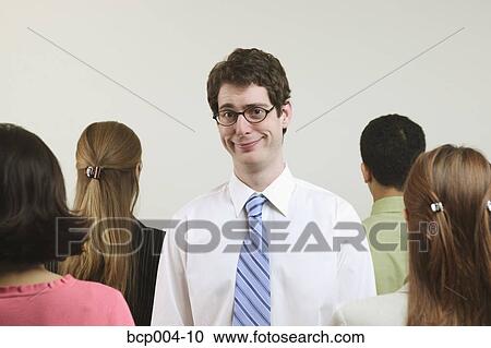 A young, tall businessman surrounded by four colleagues. View Large Photo Image Stock Image - A young, tall businessman surrounded by four colleagues. . Fotosearch