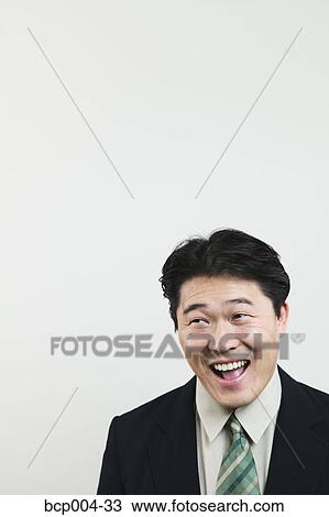 Asian man in a business suit laughing. View Large Photo Image Stock Image - Asian man in a business suit laughing.. Fotosearch