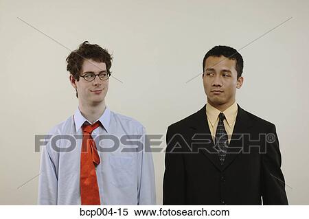 Two young businessmen eyeing each other. View Large Photo Image Stock Photography - Two young businessmen eyeing each other.. Fotosearch