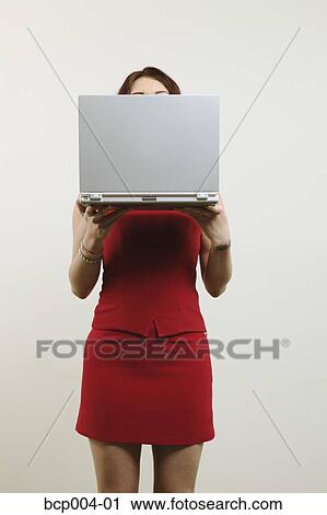 Woman hiding her face behind a laptop computer. View Large Photo Image Stock Image - Woman hiding her face behind a laptop computer.. Fotosearch