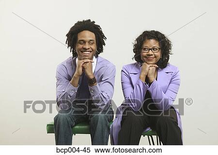 Young couple seated side by side. View Large Photo Image Stock Photography - Young couple seated side by side.. Fotosearch