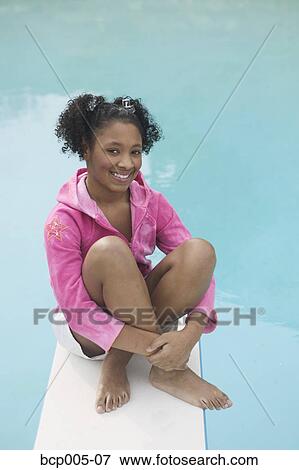 A teenage girl sitting on a diving board. View Large Photo Image Stock Photo - A teenage girl sitting on a diving board. . Fotosearch