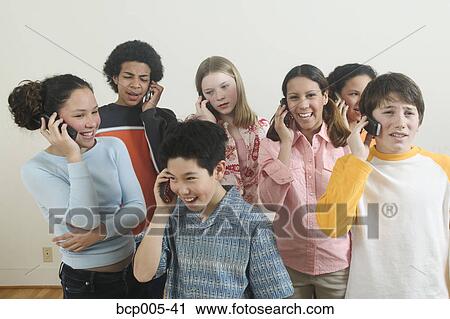Seven teenagers talking on mobile phones. View Large Photo Image Stock Image - Seven teenagers talking on mobile phones. . Fotosearch