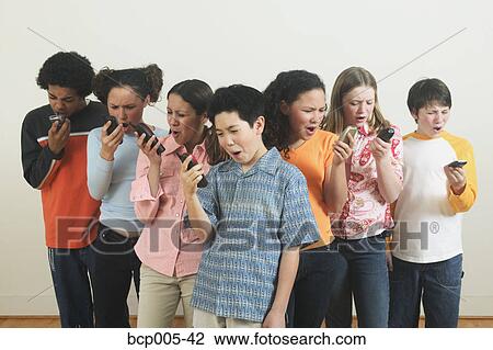 Stock Image - Seven teenagers talking on mobile phones. . Fotosearch