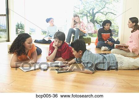 Teenage girls and boys lying on the floor and doing homework. View Large Photo Image Stock Photograph - Teenage girls and boys lying on the floor and doing homework.. Fotosearch