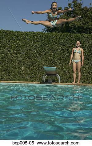 Twin girl watches her sister leap from a diving board. View Large Photo Image Stock Photography - Twin girl watches her sister leap from a diving board.. Fotosearch