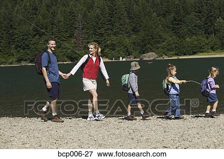Family hiking at the side of a lake. View Large Photo Image Stock Photo - Family hiking at the side of a lake.. Fotosearch