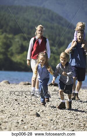 Family hiking at the side of a lake. View Large Photo Image Stock Photo - Family hiking at the side of a lake.. Fotosearch