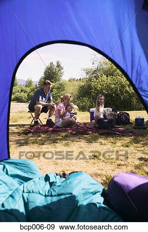 Family relaxing at a campsite. View Large Photo Image Stock Photo - Family relaxing at a campsite. . Fotosearch