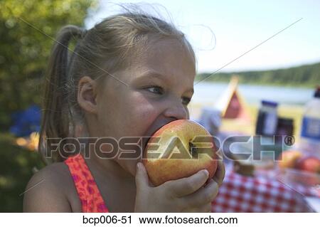 Little girl with pigtails eating an apple View Large Photo Image Stock Image - Little girl with pigtails eating an apple. Fotosearch