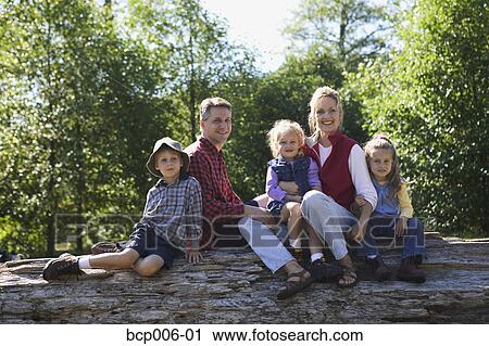 Portrait of a family of five sitting on a log. View Large Photo Image Stock Image - Portrait of a family of five sitting on a log. . Fotosearch