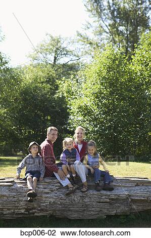Portrait of a family of five sitting on a log. View Large Photo Image Stock Image - Portrait of a family of five sitting on a log. . Fotosearch