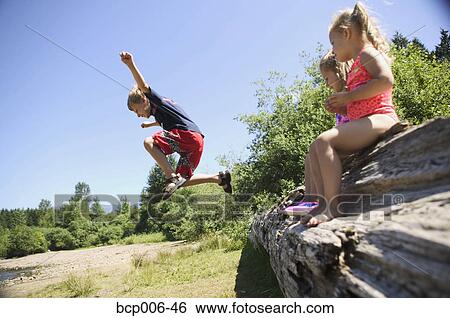 Sisters and brother playing around a large fallen tree. View Large Photo Image Stock Photograph - Sisters and brother playing around a large fallen tree.. Fotosearch