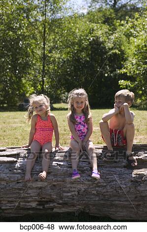 Sisters and brother pose outside on a log. View Large Photo Image Stock Photo - Sisters and brother pose outside on a log.. Fotosearch