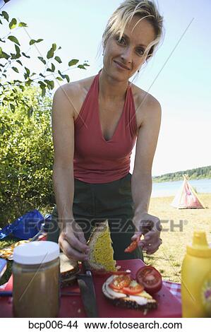 Woman making sandwiches at a campsite picnic. View Large Photo Image Picture - Woman making sandwiches at a campsite picnic.. Fotosearch