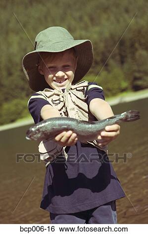 Young boy holding the fish he caught. View Large Photo Image Stock Photograph - Young boy holding the fish he caught.. Fotosearch