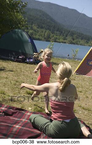 Young girl running to her mother at a campsite. View Large Photo Image Stock Photo - Young girl running to her mother at a campsite.. Fotosearch
