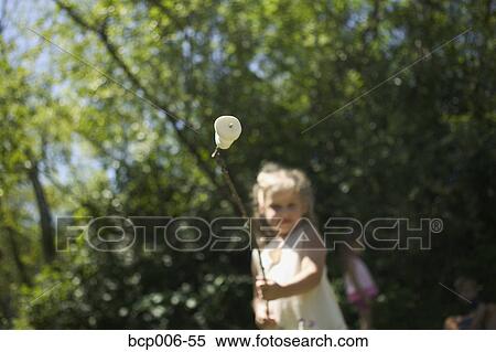 Stock Photography - Young girl with a marshmallow on a stick.. Fotosearch