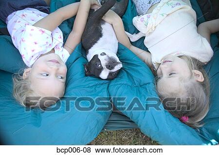 Young sisters and their dog on sleeping bags. View Large Photo Image Stock Photo - Young sisters and their dog on sleeping bags. . Fotosearch
