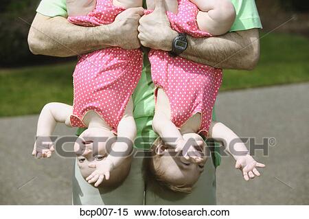Father holding his twin babies upside down. View Large Photo Image Stock Photography - Father holding his twin babies upside down.. Fotosearch