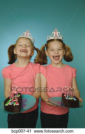 Studio portrait of young, twin Caucasian girls holding birthday cake. View Large Photo Image Stock Image - Studio portrait of young, twin Caucasian girls holding birthday cake.. Fotosearch