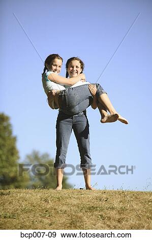 Teenage girl holding her twin sister. View Large Photo Image Stock Photo - Teenage girl holding her twin sister.. Fotosearch