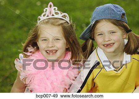 Stock Photo - Twin girls dressed in contrasting styles.. Fotosearch