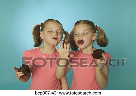 Twin girls eating chocolate cake. View Large Photo Image Stock Image - Twin girls eating chocolate cake.. Fotosearch