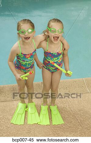 Twin girls standing poolside. View Large Photo Image Stock Photography - Twin girls standing poolside.. Fotosearch