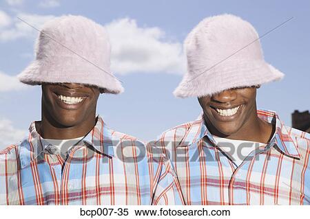 Twin teenage boys in matching hats and shirts. View Large Photo Image Stock Photography - Twin teenage boys in matching hats and shirts.. Fotosearch