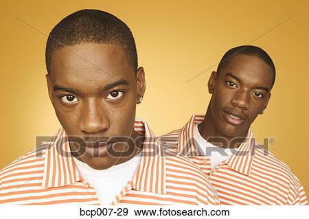Stock Photo - Twin teenage boys in matching shirts.. Fotosearch