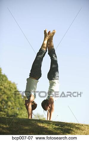 Twin teenage girls doing back to back handstands. View Large Photo Image Stock Photo - Twin teenage girls doing back to back handstands.. Fotosearch